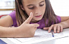 seorang anak mengerjakan PR matematika dan menghitung dengan jarinya