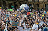 протестующие держат большой глобус планеты Земля