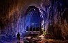 一個人在一個巨大的拱門通向夜空的洞穴中