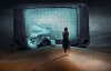 شاشة تلفزيون في الصحراء مع امرأة تقف أمامها وآخر في منتصف الطريق خارج الشاشة