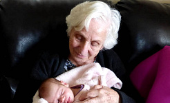 en bedstemor (eller måske en oldemor), der holder et nyfødt barn