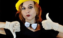 eine junge Frau, die eine Fliege und ein Clownsgesicht mit weißen Handschuhen trägt, die einen Daumen nach oben und einen Daumen nach unten geben