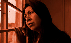 μια γυναίκα που κοιτάζει έξω από ένα παράθυρο