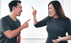 زن و شوهری که با هم دعوا می کنند و با انگشت به طرف هم اشاره می کنند
