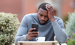 en mand tilsyneladende meget stresset, mens han kiggede på sin telefon