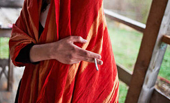 ang taong naka-red shawl ay may hawak na sigarilyo