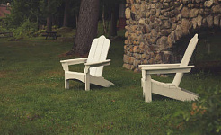 hai chiếc ghế trống trên bãi cỏ từ một bức tường đá
