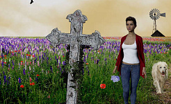 een vrouw bij een oude grafsteen met een windmolen op de achtergrond