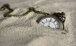 ساعة جيب شبه مدفونة في الرمال