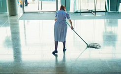 عورت کمرشل ایریا میں فرش صاف کر رہی ہے۔