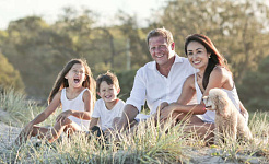 eine fröhliche Familie, die draußen auf einer Wiese zusammensitzt