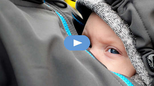 תינוק מוגן בתוך הז'קט של אמו על חזה