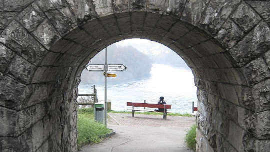 personne assise sur un banc au bout d'un tunnel avec des panneaux pointant vers la gauche ou la droite