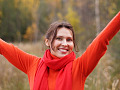 une femme souriante avec les bras levés dans un geste expansif