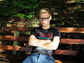 a very frustrated young man sitting on a bench with his arms crossed.