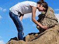 en kvinde, der laver en sandklippeskulptur