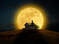满月笼罩着房子后面的天空