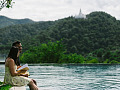 Ein Paar sitzt am Ufer eines Sees und liest ein Buch
