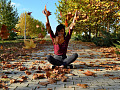 Woman sitting outside with arms up in a gesture of happiness and success. 