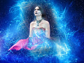 donna seduta circondata dall'energia e dal cielo stellato