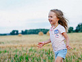một đứa trẻ vui vẻ chạy qua cánh đồng