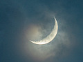 luna creciente vista a través de las nubes