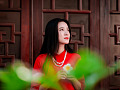ung kvinna i en röd klänning tittar upp mot himlen