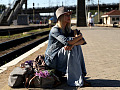 기차역에서 여행가방 위에 앉아 있는 여자