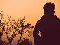 uomo in piedi da solo fuori al tramonto