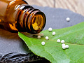 homeopatiska kulor hälls ut på ett löv
