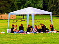 Photo of a group gathered under an outdoor canopy. Image by Thomas G. from Pixabay. 