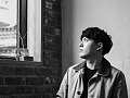 A young man sitting at a table and staring out the window. Image by JUNO KWON from Pixabay. 