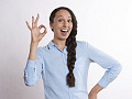 Frau mit einem breiten Lächeln und Fingern in einem „A-OK“-Symbol