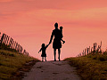 woman walking away holding two small children. Image by Mohamed Hassan from Pixabay. 