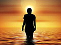kvinde stående i vandet ved solopgang