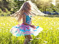 νεαρή κοπέλα χορεύει και στροβιλίζεται έξω σε ένα λιβάδι
