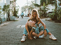 mother and child sitting on the ground in the middle of a cobblestone street