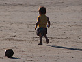 un bambino molto piccolo, solo su una spiaggia