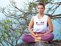 jovem sentada ao ar livre em posição de meditação