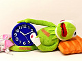 seekor katak yang sakit berbaring sambil memegang jam weker