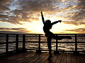 a woman dancing on a pier