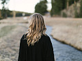 Una donna vista di spalle mentre guarda il sentiero davanti a lei. Immagine di brittywing da Pixabay.