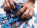 Mani che mescolano tutti i pezzi di un puzzle. Immagine di Hans da Pixabay.