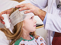una donna con una benda sulla testa in un ambiente ospedaliero