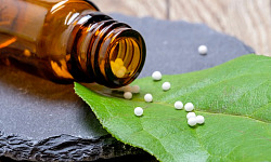 homeopatiese bolletjies op 'n blaar uitgegooi