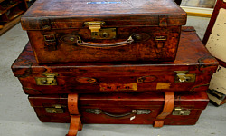 kolme avattua vanhaa matkalaukkua pinottuina päällekkäin