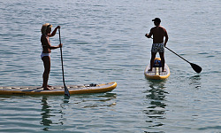 dalawang tao, isang lalaki at isang babae, sa mga paddle board