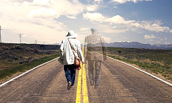 Ein älteres Paar geht Händchen haltend mitten auf der Straße entlang