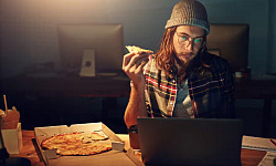 Manerer en pizza foran en skærm.