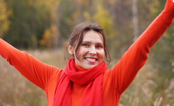a woman smiling with arms raised up in expansive gesture